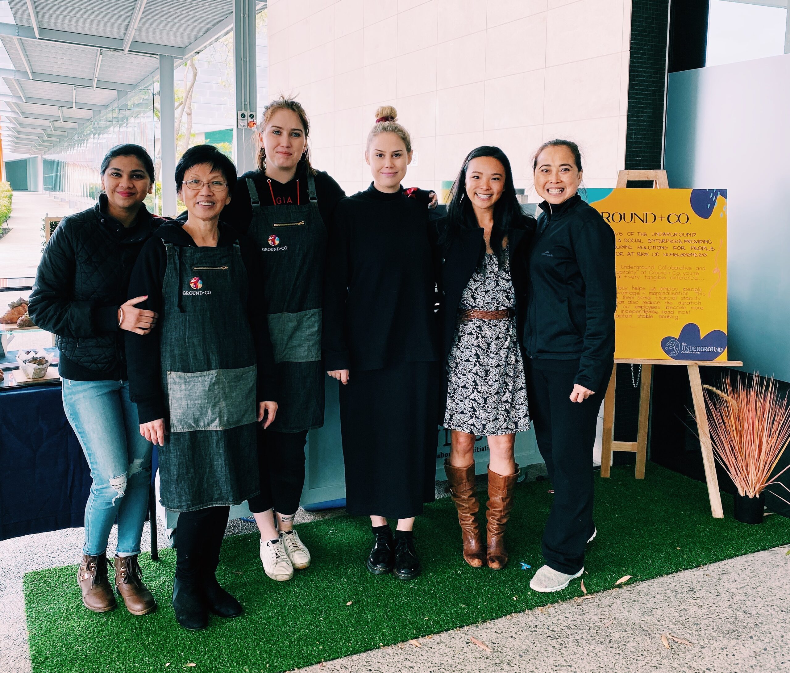 Six women standing in front of a coffee cart outside the EY Building